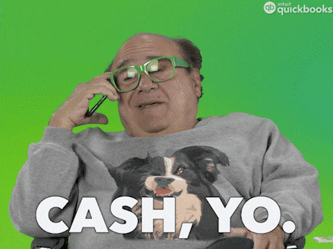 Actor Danny Devito on the phone wearing a dog shirt. Caption of gif says "CASH, YO."